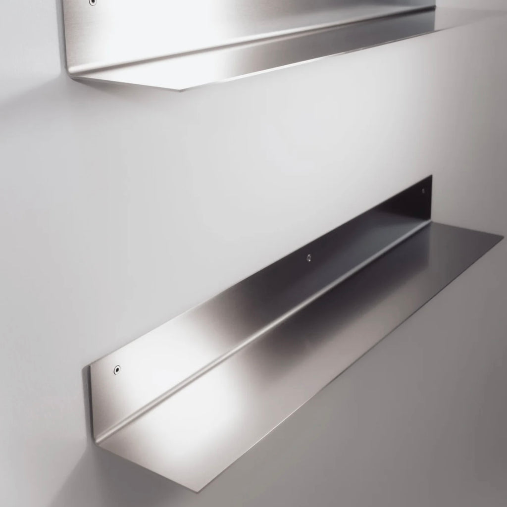 Metallic wall-mounted shelf on a plain background
