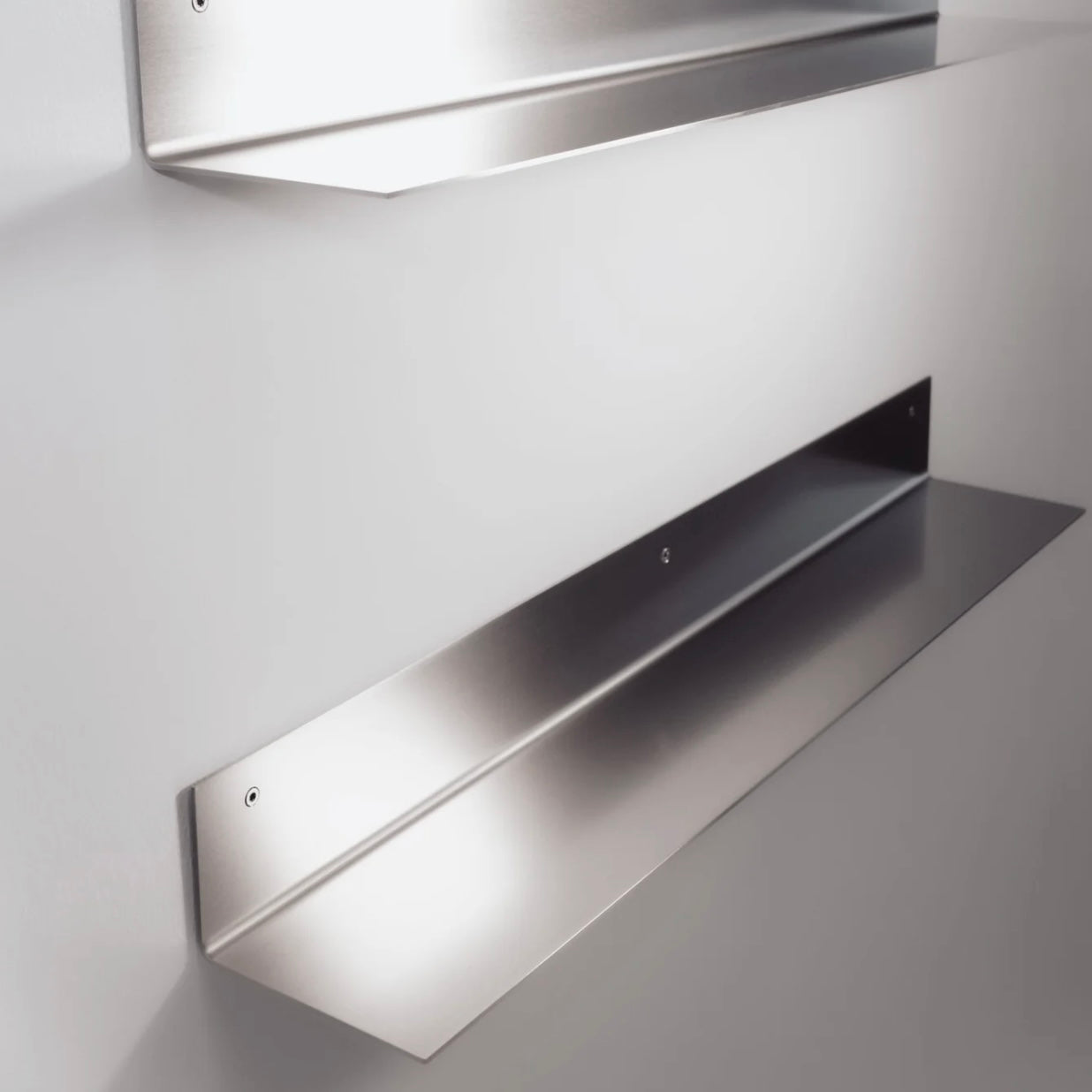 Metallic wall-mounted shelf on a plain background