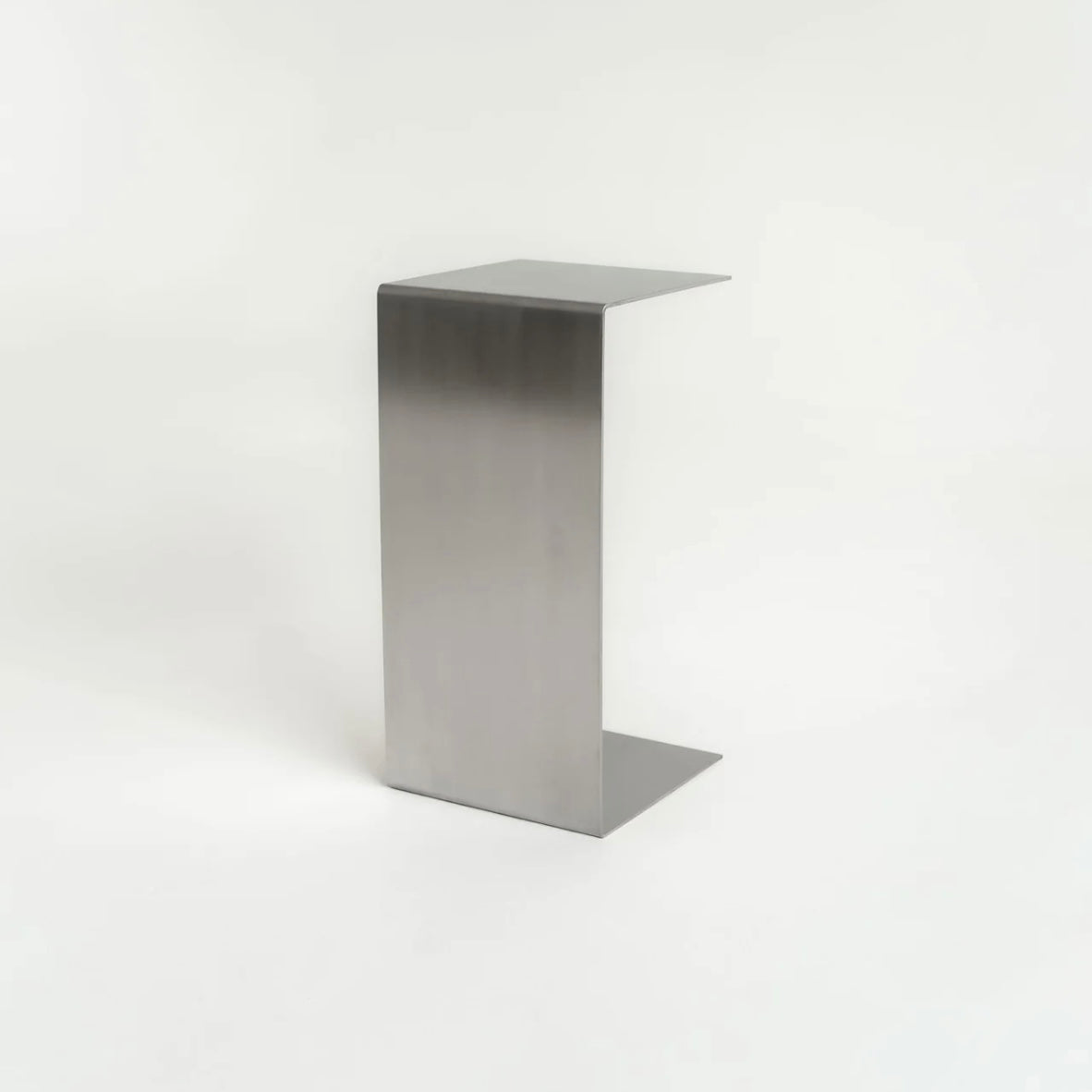 Monolith steel side table with bold minimal design, precision-cut metal construction, industrial bedside table for modern living room or bedroom