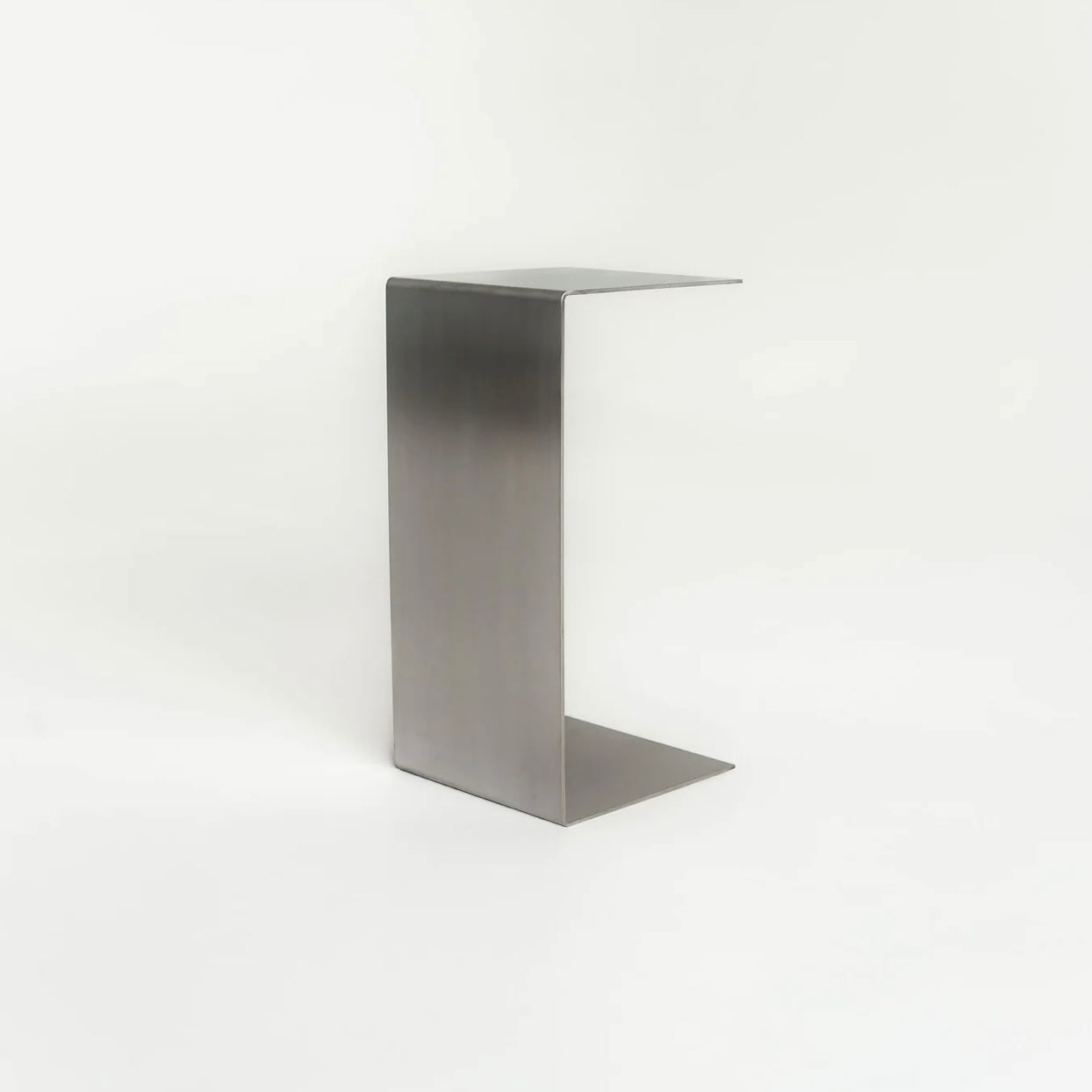 Monolith steel side table with bold minimal design, precision-cut metal construction, industrial bedside table for modern living room or bedroom