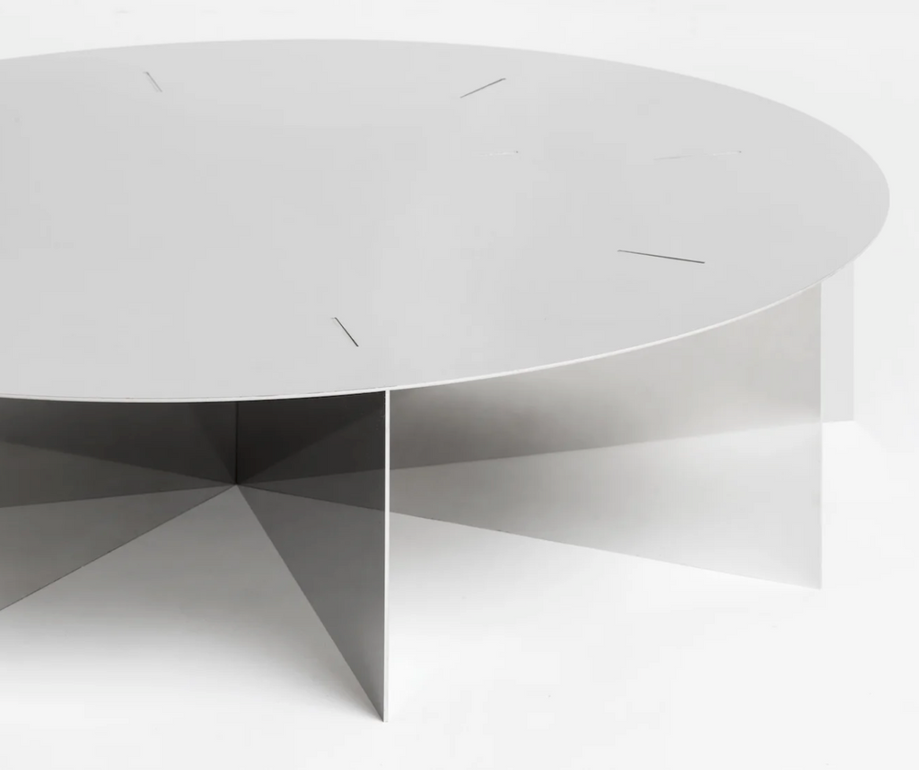 Radial steel coffee table with round top and geometric base design, precision-cut metal construction, minimal industrial center table for living room