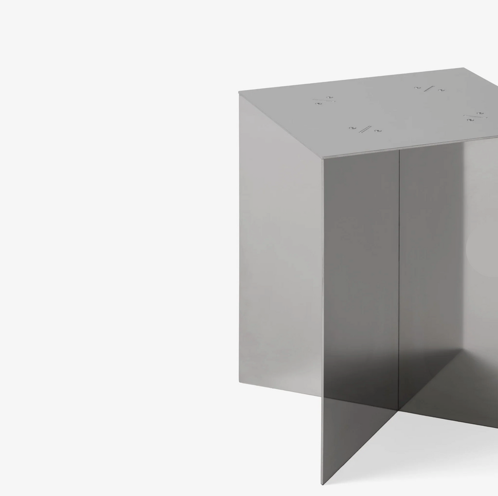 Interlocked steel side table with slot-and-lock design, minimal industrial look, precision-cut metal construction, modern bedside table for living room or bedroom